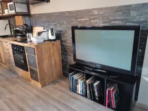 a flat screen tv sitting on a stand in a kitchen at Casa Pepito in Bogliasco