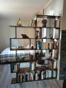uma estante cheia de livros ao lado de uma cama em Casa Pepito em Bogliasco