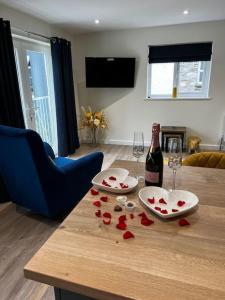 a table with a bottle of wine and hearts on it at Ulverston stunning 1 bedroom apartment in Ulverston