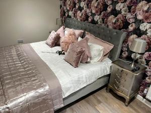 a bedroom with a bed with pink and white pillows at Ulverston stunning 1 bedroom apartment in Ulverston