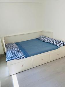 a bed with a white frame and a blue mattress at Apartamento Cuidad Ciencias in Valencia