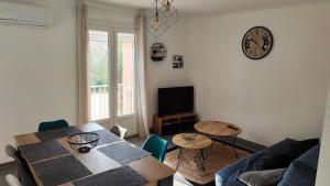 a living room with a table and a tv at T3 45M2, Cap d'Adge,Secteur Falaise,4-6 pers, Clim, Fibre - WIFI, 100m plage in Cap d'Agde