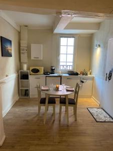 uma cozinha com mesa e cadeiras num quarto em Appartement de caractère hyper centre em Ploërmel