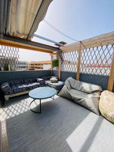 a room with a couch and a table on a balcony at Golden Wave Surf Roof Terrace in Corralejo