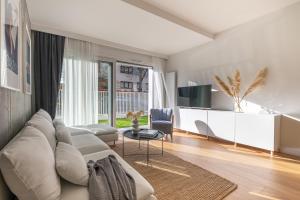 un soggiorno con divano bianco e TV di S35 Apartments Gdynia Orłowo a Gdynia