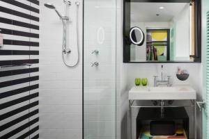 a bathroom with a sink and a shower at QT Gold Coast in Gold Coast
