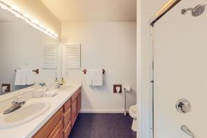 La salle de bains est pourvue de 2 lavabos et d'une douche. dans l'établissement Stone Creek Lodge, à Avon