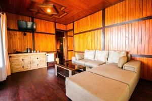 a living room with a couch and a tv at Munduk Menir Villas in Munduk