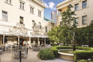 einen Innenhof mit Tischen, Stühlen und einem Brunnen in der Unterkunft Adina Apartment Hotel Adelaide Treasury in Adelaide