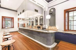 a bar in a room with chairs and tables at Adina Apartment Hotel Adelaide Treasury in Adelaide