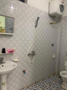 a bathroom with a shower with a sink and a toilet at Như Quỳnh Hotel in Bảo Lạc