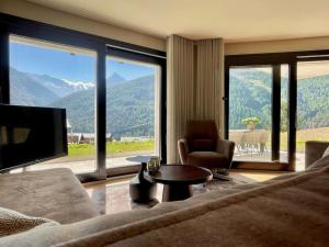 un soggiorno con un divano e una grande finestra di Hollywood 1 - A luxury, comfortable and spacious apartment located directly on the slopes! a Saas-Fee