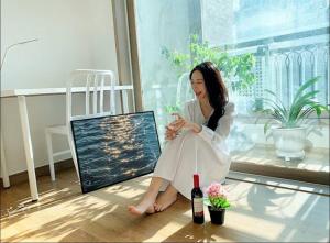 uma mulher sentada no chão com uma garrafa de vinho em Tranquilo paradise em Seul