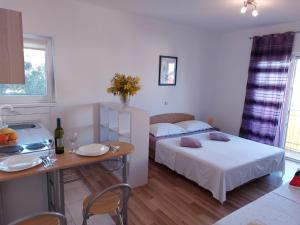 a room with two beds and a table with a table sidx sidx sidx at Studio apartman I&R in Ciovo