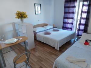 a hotel room with two beds and a table and a table sidx sidx at Studio apartman I&R in Ciovo +19 photos