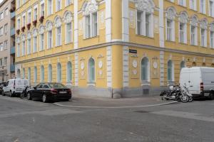 żółty budynek z samochodami zaparkowanymi przed nim w obiekcie Levestate Apartments Klährgasse Vol 2 w Wiedniu