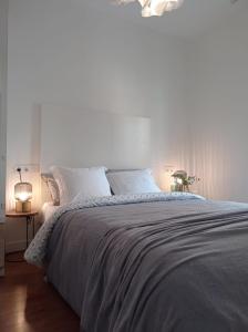 a white bedroom with a large bed with white pillows at Nido MAD in Madrid