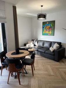 uma sala de estar com um sofá e uma mesa em Ogrody Pieniawskie Apartamenty 37 em Polanica-Zdrój
