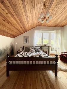 a bedroom with a large bed with a wooden ceiling at Na stoku in Korbielów