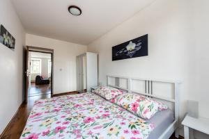 1 Schlafzimmer mit einem Bett mit Blumenbettdecke in der Unterkunft Apartmán Hartmanice in Sušice