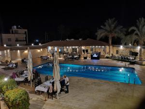 a group of people standing by a pool at night at Bab Al Shams Resort in Jericho