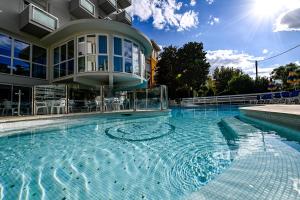 une grande piscine en face d'un bâtiment dans l'établissement Hotel Torretta, à Cattolica