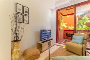 A television and/or entertainment centre at XPCE D CARLOS GARDENS Apartment