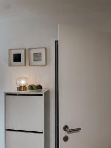 a white refrigerator with a bowl of fruit on top of it at Traunsee Design Apartment for 2 People in Gmunden