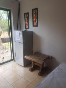 a room with a bench next to a refrigerator at The Aces - NUDE - SunEden Family Naturist Resort in Pretoria
