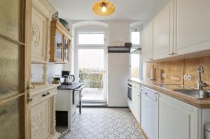 eine Küche mit weißen Schränken und einer Spüle in der Unterkunft Ferienwohnung Herrenzimmer mit Kamin und Terrasse in Annaberg-Buchholz + 6 Fotos