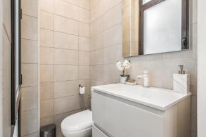 y baño con aseo, lavabo y espejo. en Apartamento en excelente ubicación, centro de Barcelona, en Barcelona