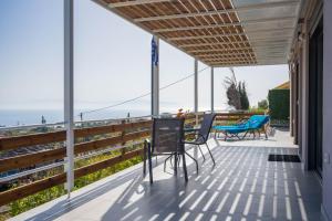 einen Balkon mit Stühlen und Meerblick in der Unterkunft Sea Forever Holiday Home in Ratzaklíon