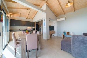 eine Küche und ein Wohnzimmer mit einem Tisch und einem Sofa in der Unterkunft Sea Forever Holiday Home in Ratzaklíon