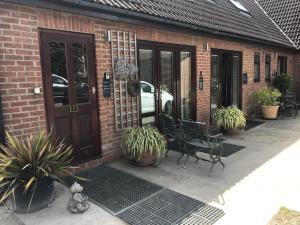 a patio with a bench and plants in front of a building at Robeanne House in Shiptonthorpe