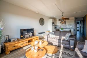 uma sala de estar com um sofá e uma mesa em Appartementencomplex Juliana 48 em De Koog