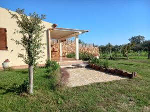 una casa con porche y un árbol en el patio en Villa Aratha en Orosei