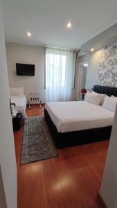 una camera d'albergo con due letti e una televisione di Il Roseto a Frosinone