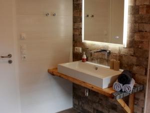 une salle de bains avec un lavabo blanc et un miroir dans l'établissement Landhaus Gerda, à Wangerland 28 autres photos