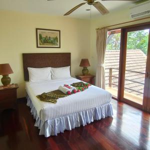 Baiyok Villa seaview and edge pool في شاطيء باتونغ: غرفة نوم بسرير ابيض كبير عليها ديكورات العيد