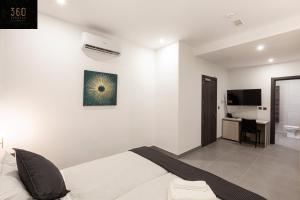 um quarto branco com uma cama e uma secretária em Lovely Modern Large Spacious Home with 7BR & WIFI by 360 Estates em Msida