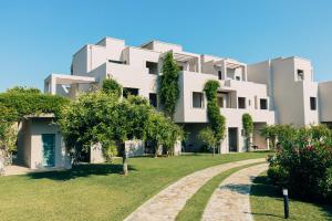 a large white building with a garden in front of it at Basiliani - CDSHotels in Otranto