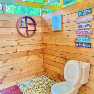 a bathroom with a toilet in a wooden wall at Lake Of The Woods PH Entire Island Exclusive Glamping in Cavinti