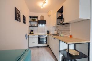 a small kitchen with white cabinets and a counter top at Moderne EG-Wohnung in Sudenburg mit Parkplatz, TOP Anbindung in Magdeburg