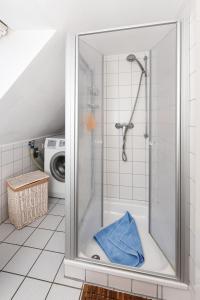 エセンスにあるFerienwohnungen Oll Freesenhuusのバスルーム(ガラスドア付きのシャワー付)