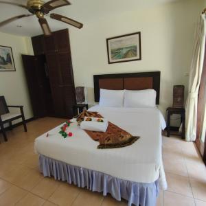 Un dormitorio con una gran cama blanca con una manta. en Baiyok Villa seaview and edge pool en Patong Beach