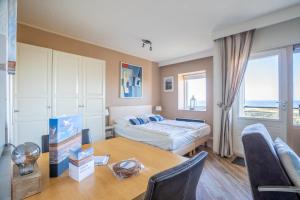 a bedroom with a bed and a table and a desk at Appartementencomplex Juliana 158 in De Koog