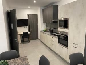 uma cozinha com armários de madeira e uma mesa com cadeiras em Lovely Modern Large Spacious Home with 7BR & WIFI by 360 Estates em Msida