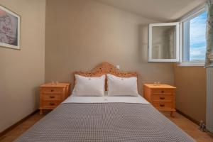 um quarto com uma cama com duas mesas de cabeceira e uma janela em Melanthi Urban em Volos