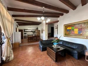 a living room with a black leather couch and a table at Villa Dalila in Lampedusa