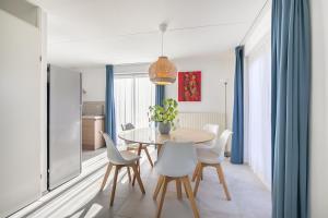 a dining room with a table and chairs at Hello Zeeland - Vakantiehuis Zwin 004 in Breskens +7 photos